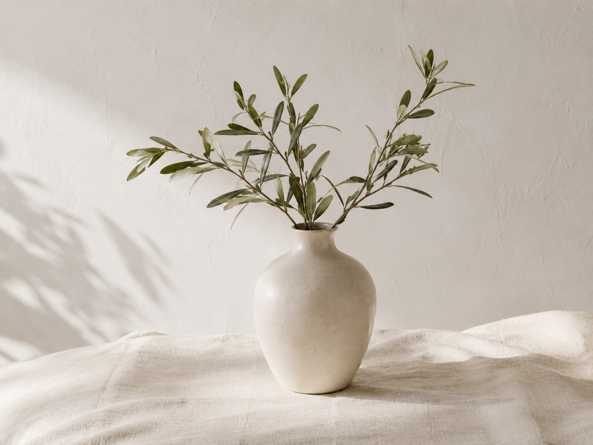 Vase Alba avec des branches d'olivier sur un drap en lin