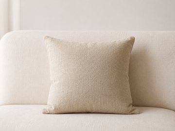 Coussin en lin naturel posé sur un canapé blanc