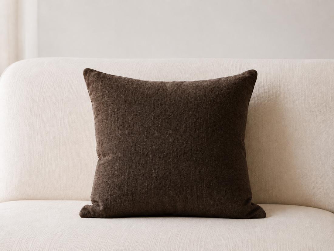 Coussin en lin brun chocolat sur un canapé blanc
